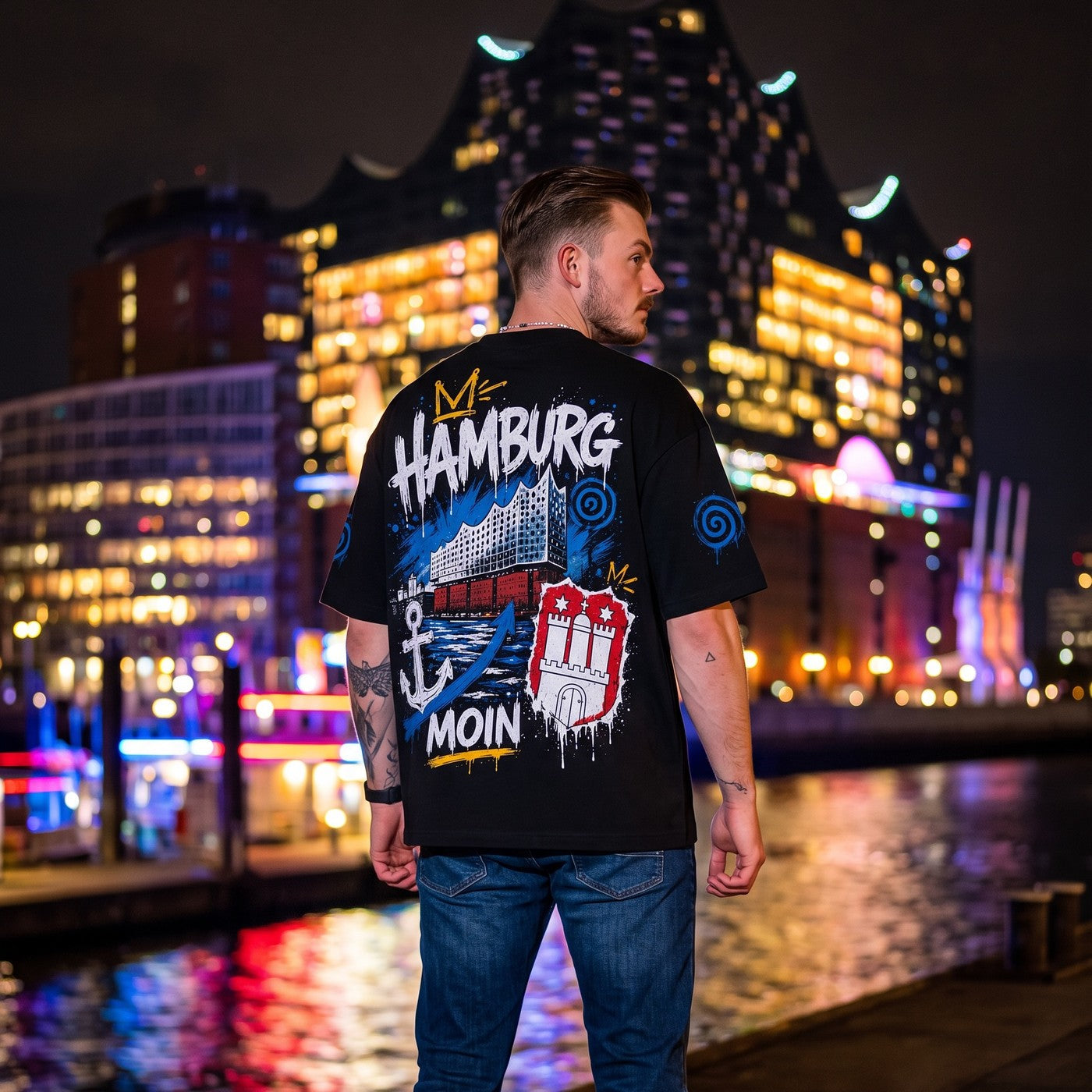 Elphi Moin Wappen Shirt Schwarz, am Model vor der Elbphilharmonie bei Nacht